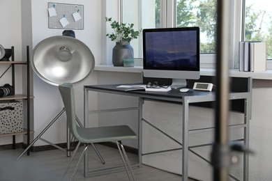 Photo of Professional lighting equipment and comfortable workplace in photo studio. Interior design