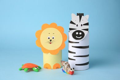 Different toys made from toilet paper hubs and plasticine on light blue background. Children's handmade ideas