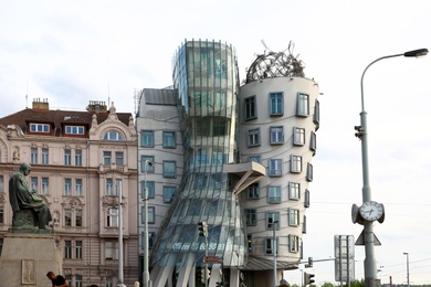 PRAGUE, CZECH REPUBLIC - APRIL 25, 2019: Dancing House and statue of Alois Jirasek on city street