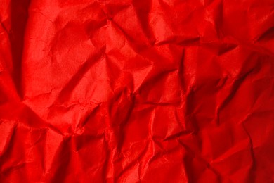 Sheet of crumpled red paper as background, top view