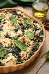 Delicious homemade spinach quiche on table, closeup