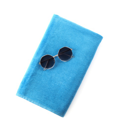 Blue towel and sunglasses on white background, top view. Beach objects