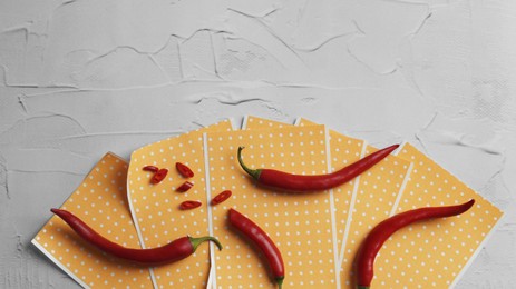 Pepper plasters and chili on white textured table, flat lay. Space for text