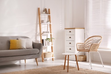 Elegant decorative ladder near sofa in living room