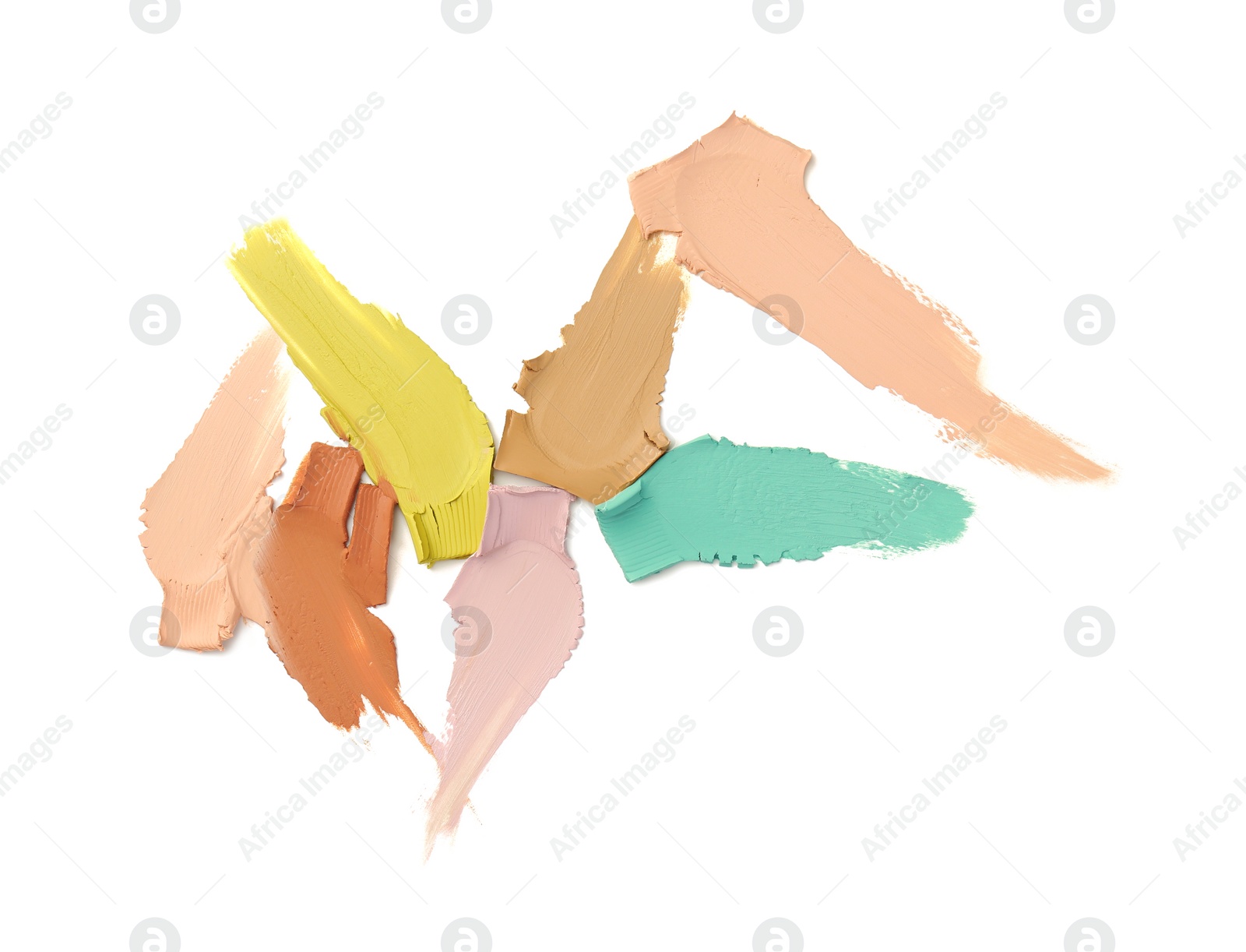 Photo of Samples of different color correcting concealers on white background, top view