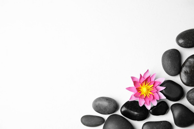 Photo of Stones with lotus flower and space for text on white background, flat lay. Zen lifestyle