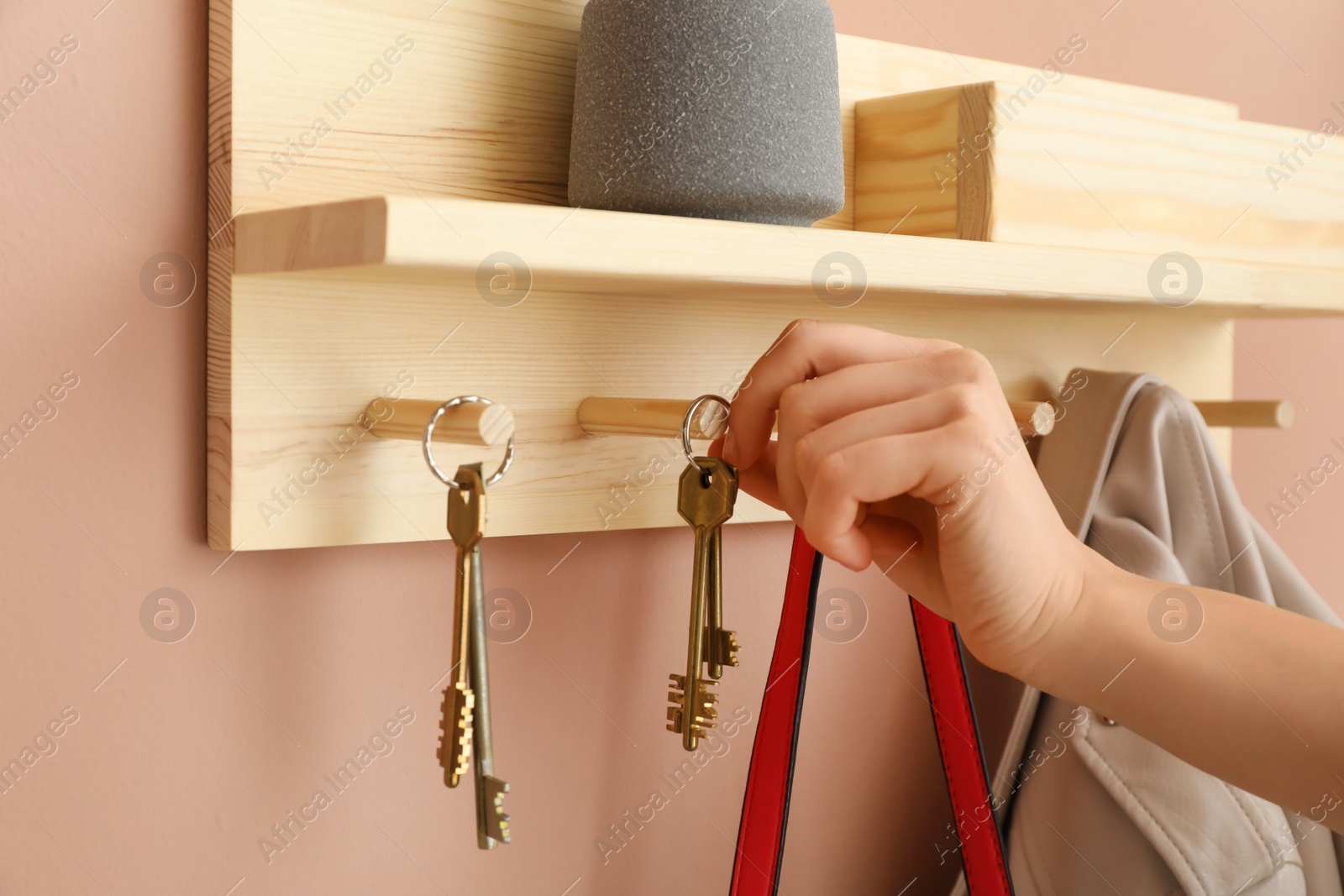 Photo of Woman taking keys from hanger in hallway, closeup