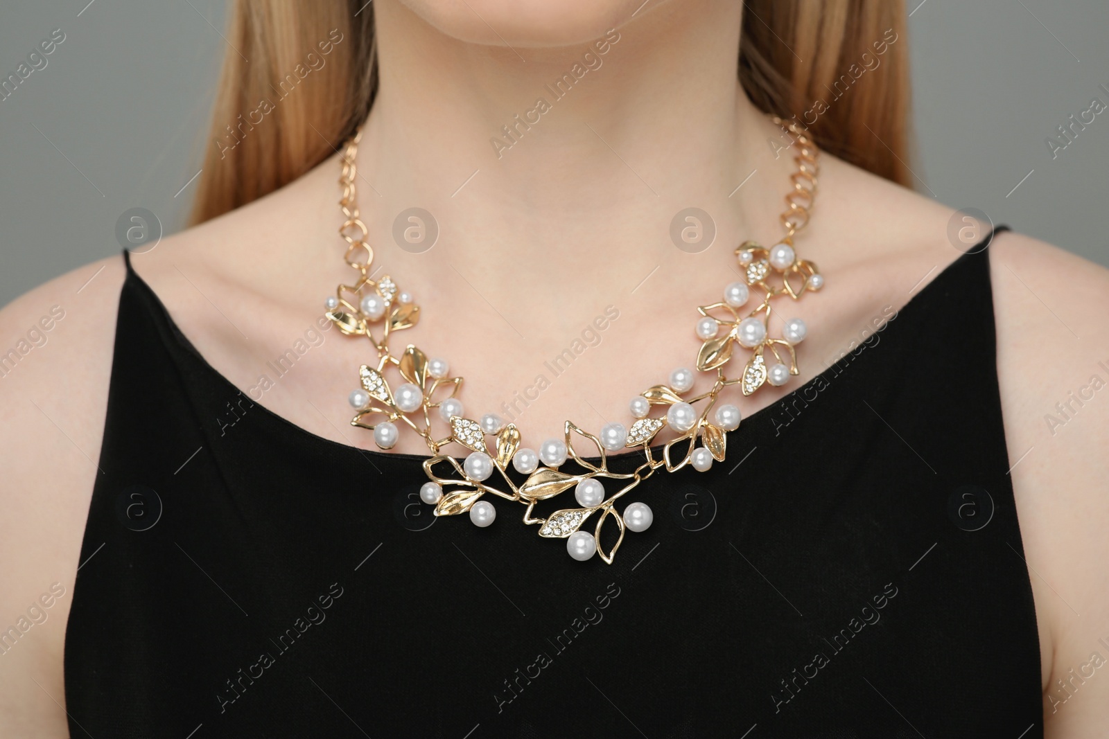 Photo of Woman with elegant necklace on gray background, closeup