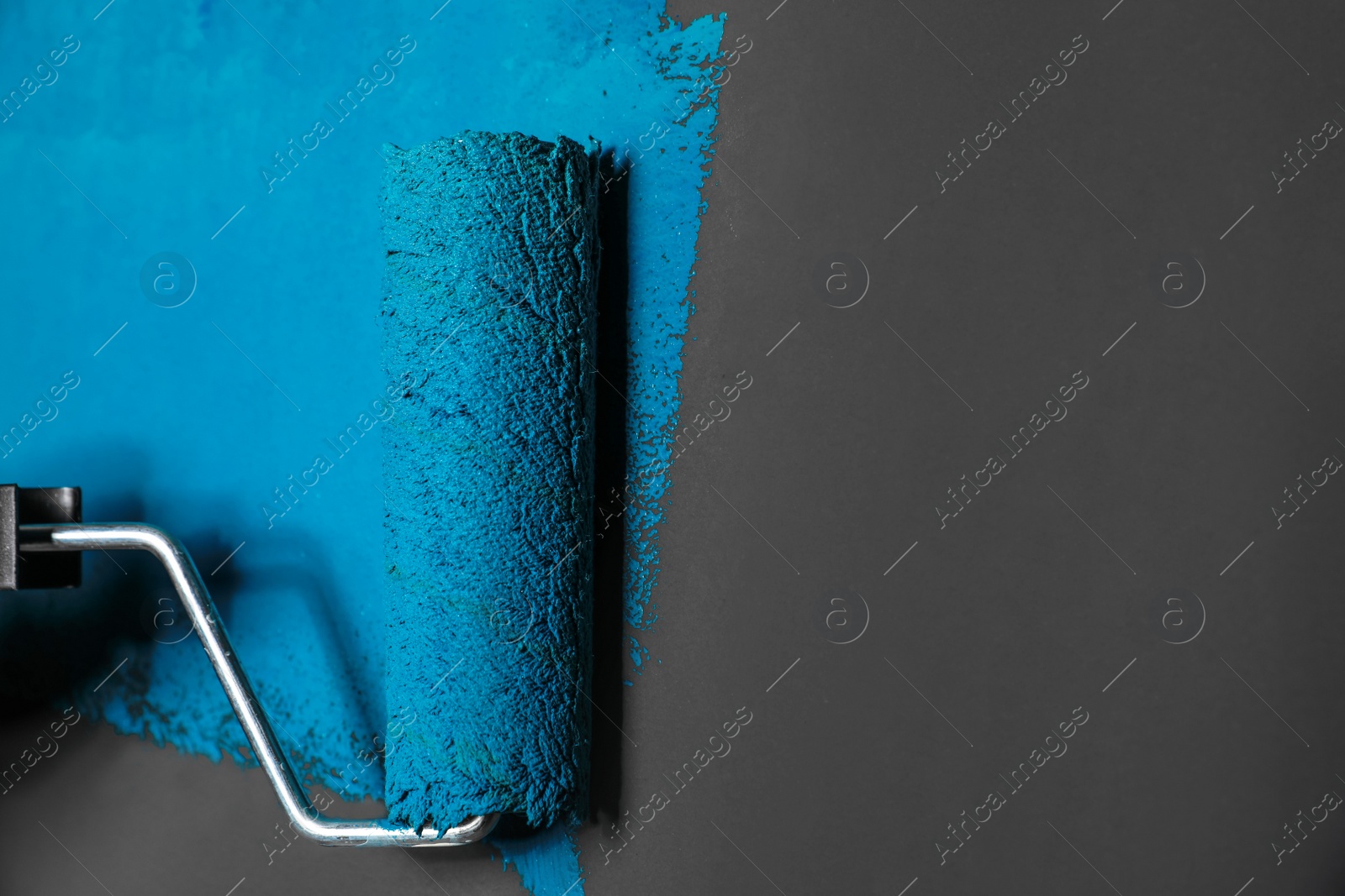 Photo of Painting grey wall with blue dye, closeup view. Space for text