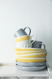Photo of Set of dinnerware on table against light background. Interior element