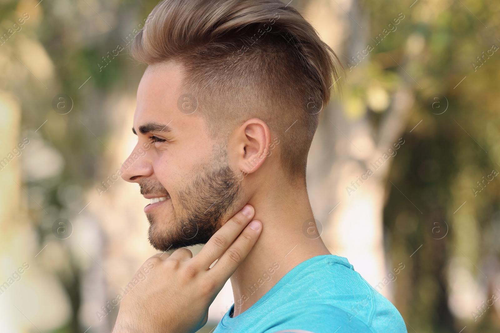 Photo of Young man checking pulse outdoors on sunny day