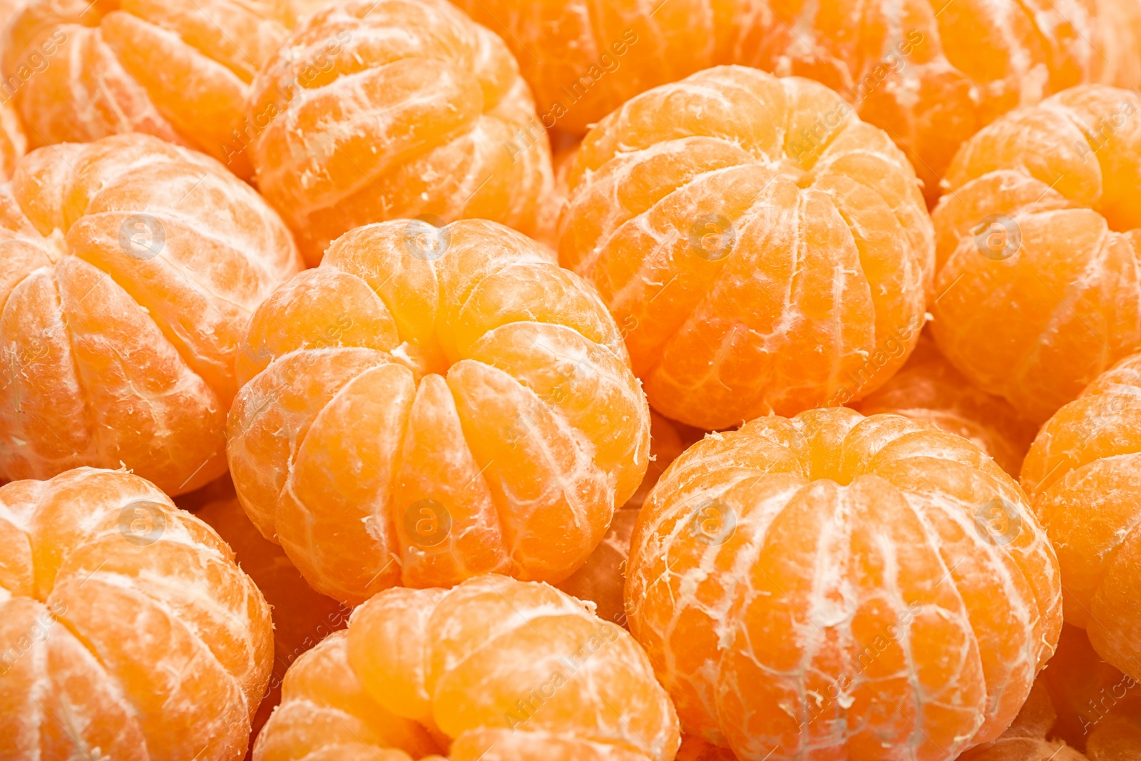 Photo of Peeled fresh ripe tangerines as background, closeup