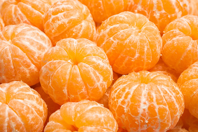 Peeled fresh ripe tangerines as background, closeup