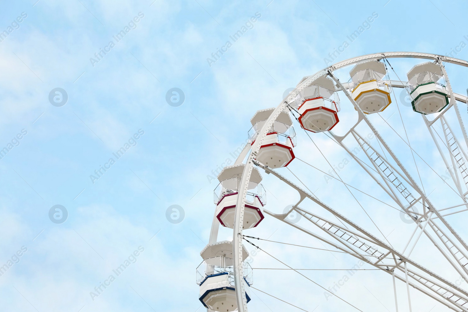 Photo of Large white observation wheel against sky, space for text