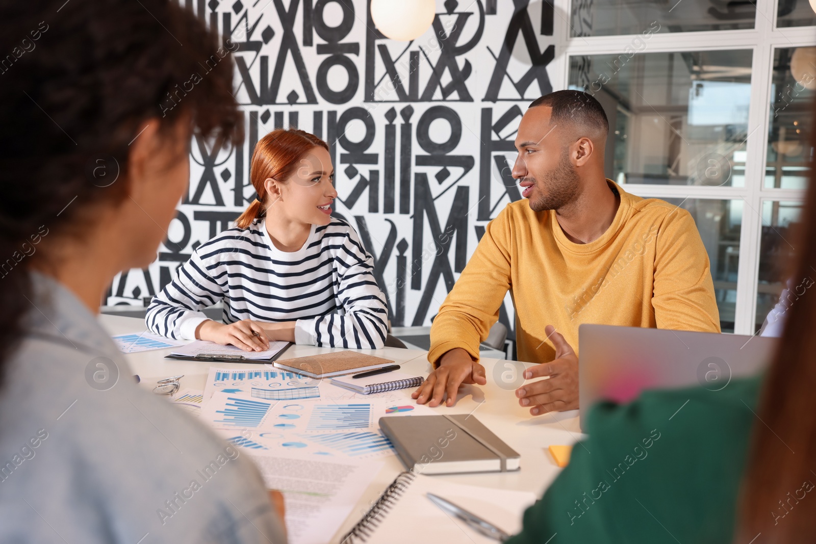 Photo of Team of employees working together at table in office. Startup project