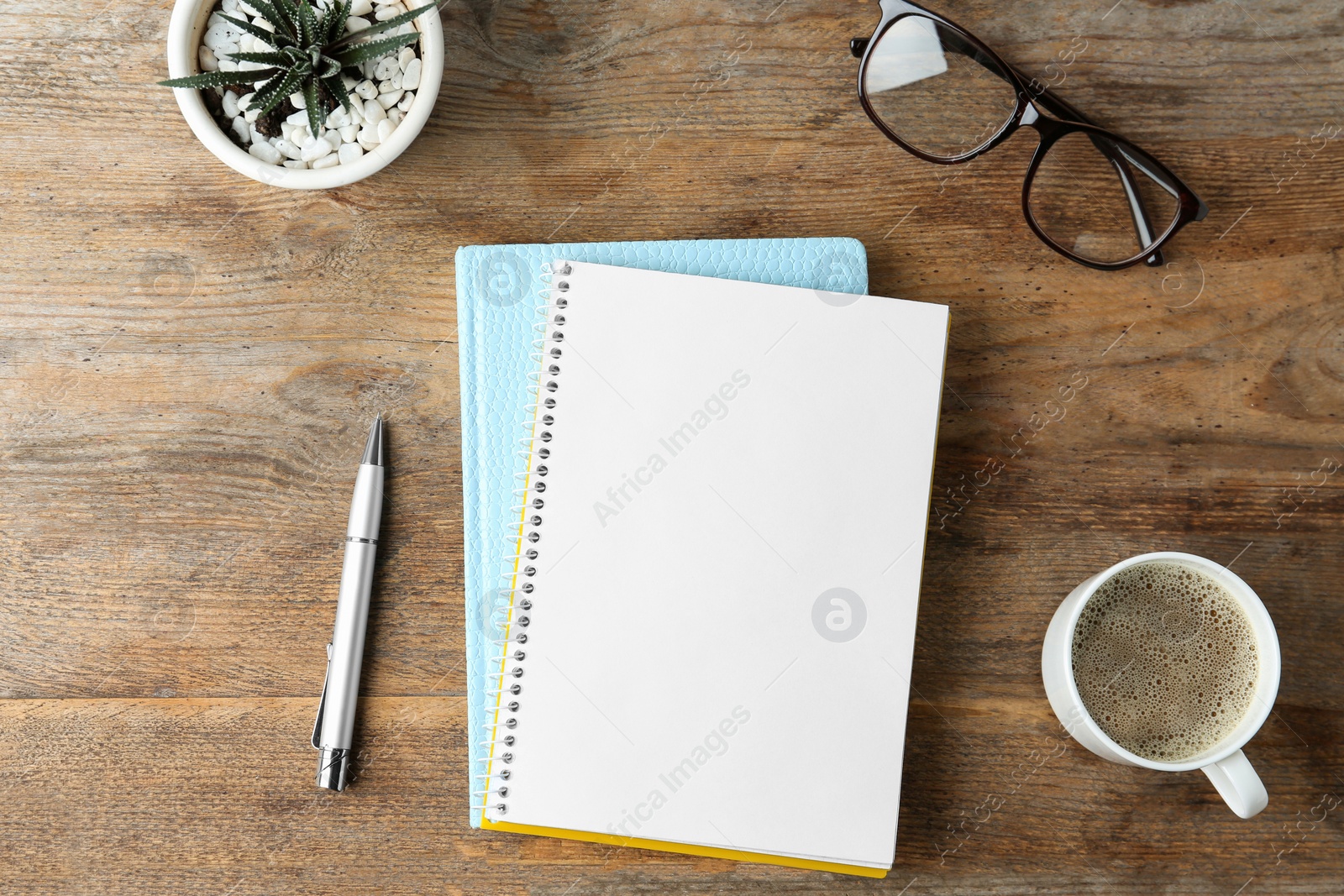 Photo of Flat lay composition with office stationery and cup of coffee on wooden table. Space for design