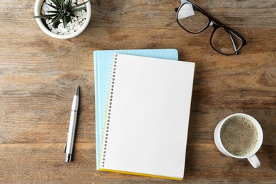 Photo of Flat lay composition with office stationery and cup of coffee on wooden table. Space for design