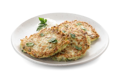 Photo of Delicious zucchini fritters with sour cream and parsley isolated on white