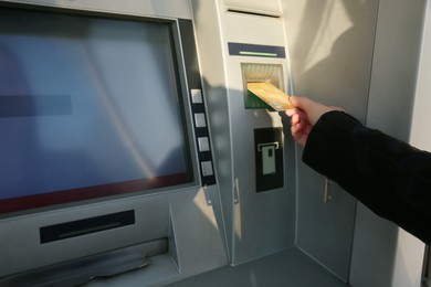 Photo of Woman using cash machine for money withdrawal outdoors, closeup