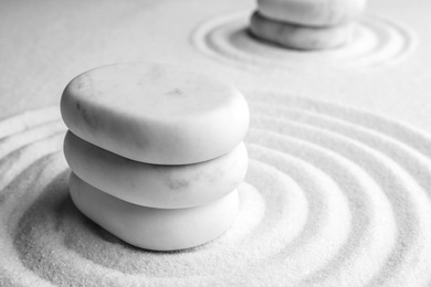 Photo of Stack of white stones on sand with pattern, closeup. Zen, meditation, harmony