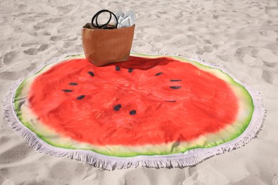 Photo of Beautiful watermelon beach towel with tassels, bag and flip flops on sand