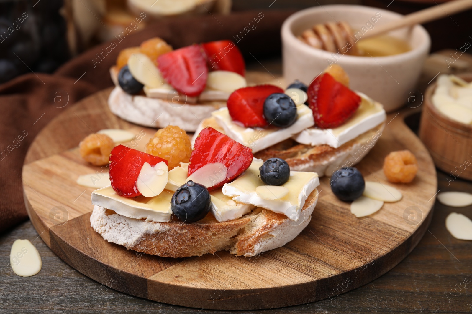 Photo of Tasty brie cheese sandwiches served on wooden table, closeup