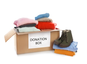 Photo of Donation box, shoes and clothes on white background