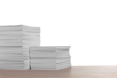 Stacks of paper sheets on wooden table against white background. Space for text