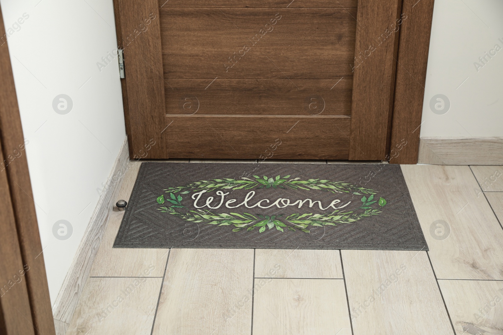 Photo of Beautiful doormat with word Welcome on floor near entrance