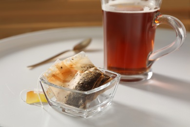 Photo of Glass bowl with used tea bags on white table