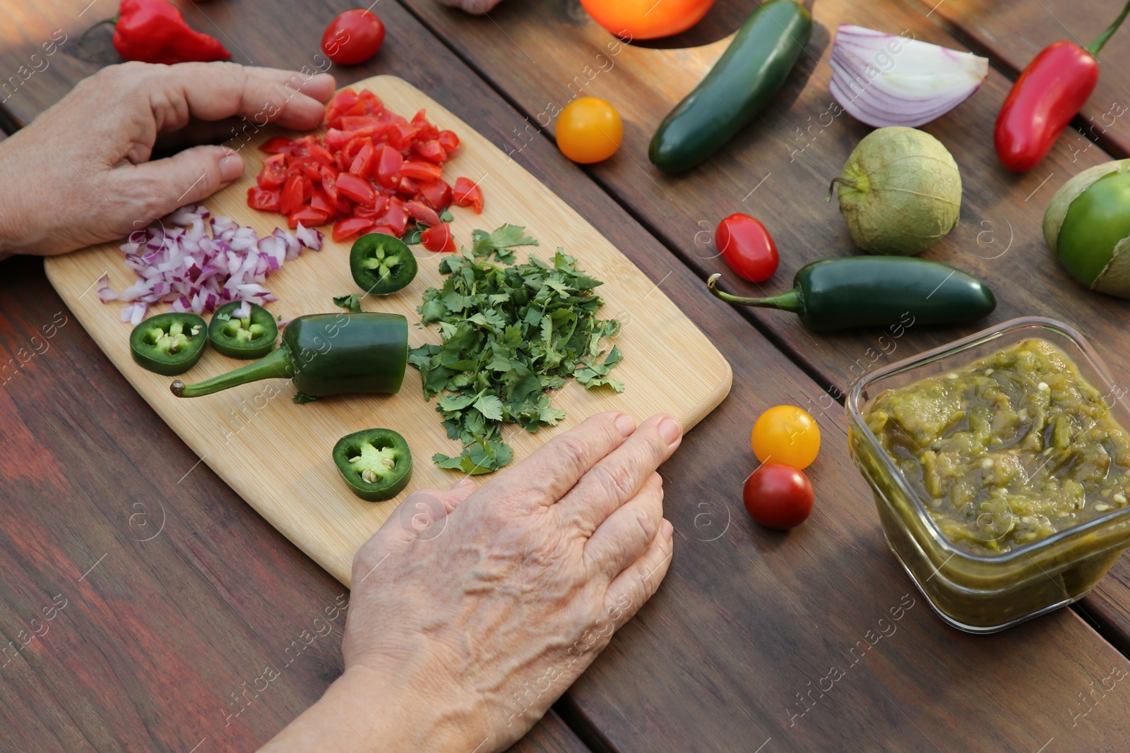 Photo of Woman preparing tasty salsa sauce at wooden table