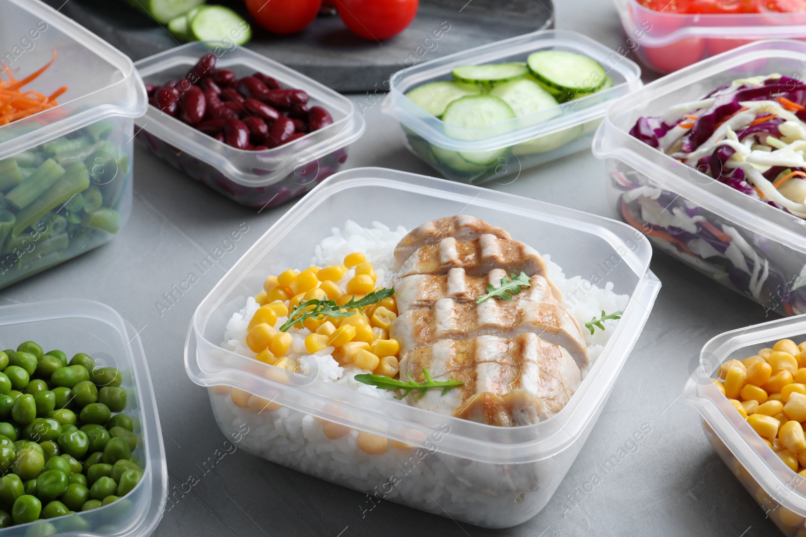 Photo of Set of plastic containers with fresh food on light table