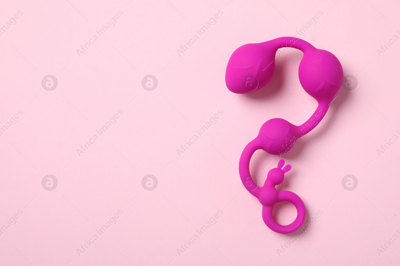 Photo of Anal balls on pink background, top view with space for text. Sex toy