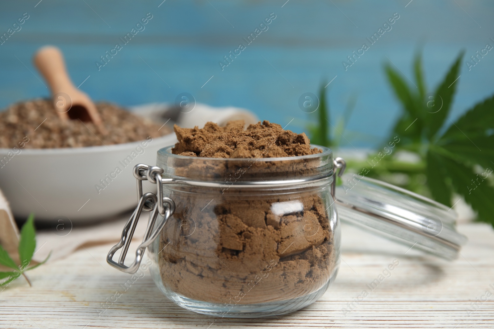 Photo of Hemp protein powder on white wooden table, closeup