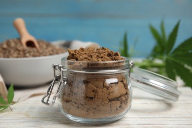 Hemp protein powder on white wooden table, closeup