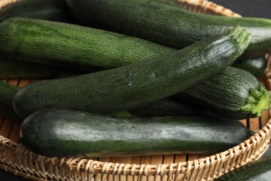 Green zucchinis in wicker basket, closeup view