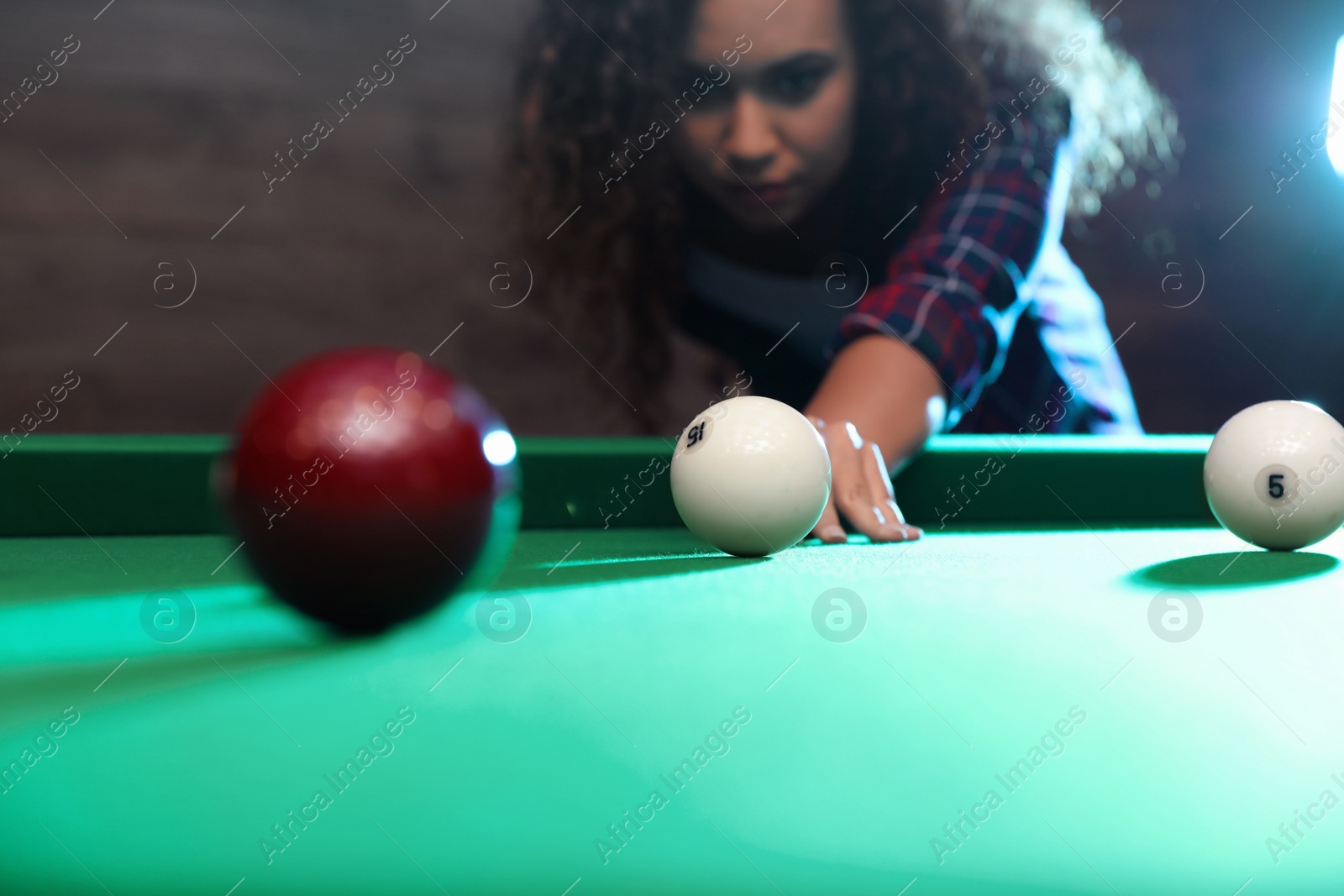 Photo of Young African-American woman playing billiard indoors