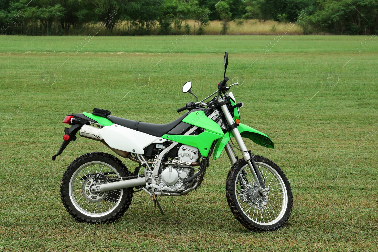 Photo of Stylish cross motorcycle on green grass outdoors