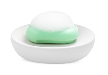 Photo of Soap bar with fluffy foam in holder on white background