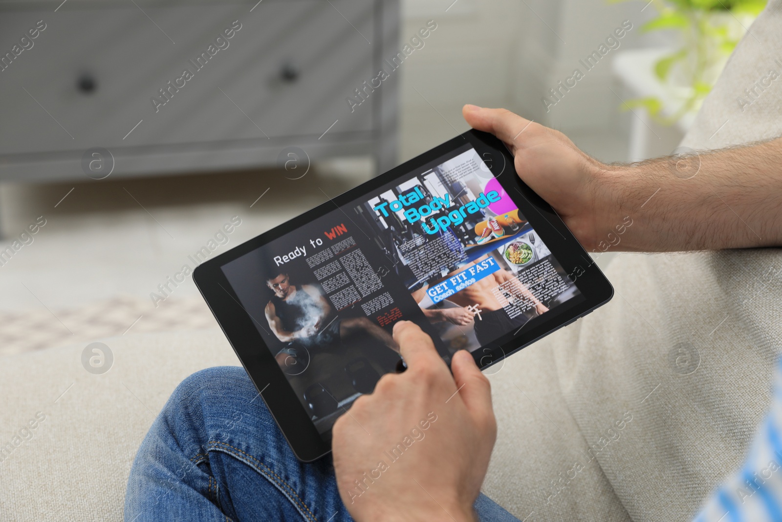 Photo of Man reading online magazine on tablet indoors, closeup