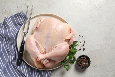 Photo of Fresh raw chicken with spices and fork on light grey table, flat lay