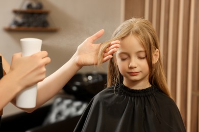 Photo of Professional hairdresser working with girl in beauty salon