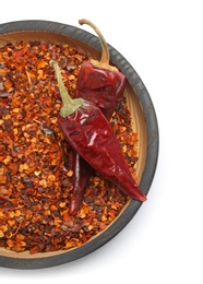 Photo of Plate with crushed chili pepper and pods on white background