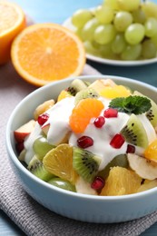 Photo of Delicious fruit salad with yogurt on table, closeup