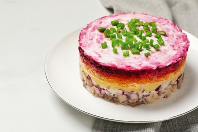 Photo of Herring under fur coat salad on white table, space for text. Traditional Russian dish