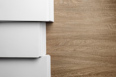 Photo of Stacks of white paper sheets on wooden table, flat lay. Space for text