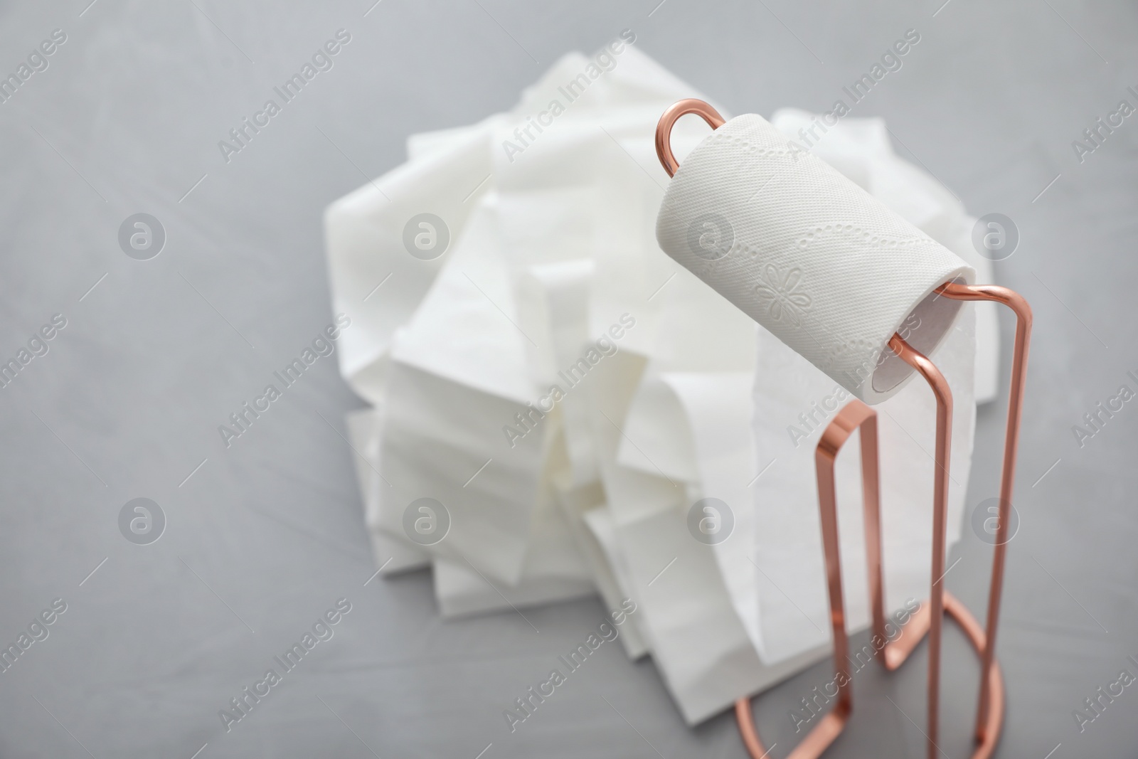 Photo of Holder with unrolled toilet paper in bathroom