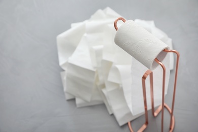 Photo of Holder with unrolled toilet paper in bathroom