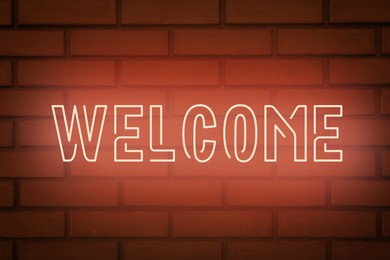 Stylish neon sign WELCOME on brick wall