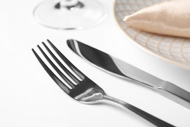Photo of Stylish shiny cutlery on white table, closeup
